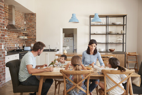 Una famiglia riunita a tavola foto iStock.